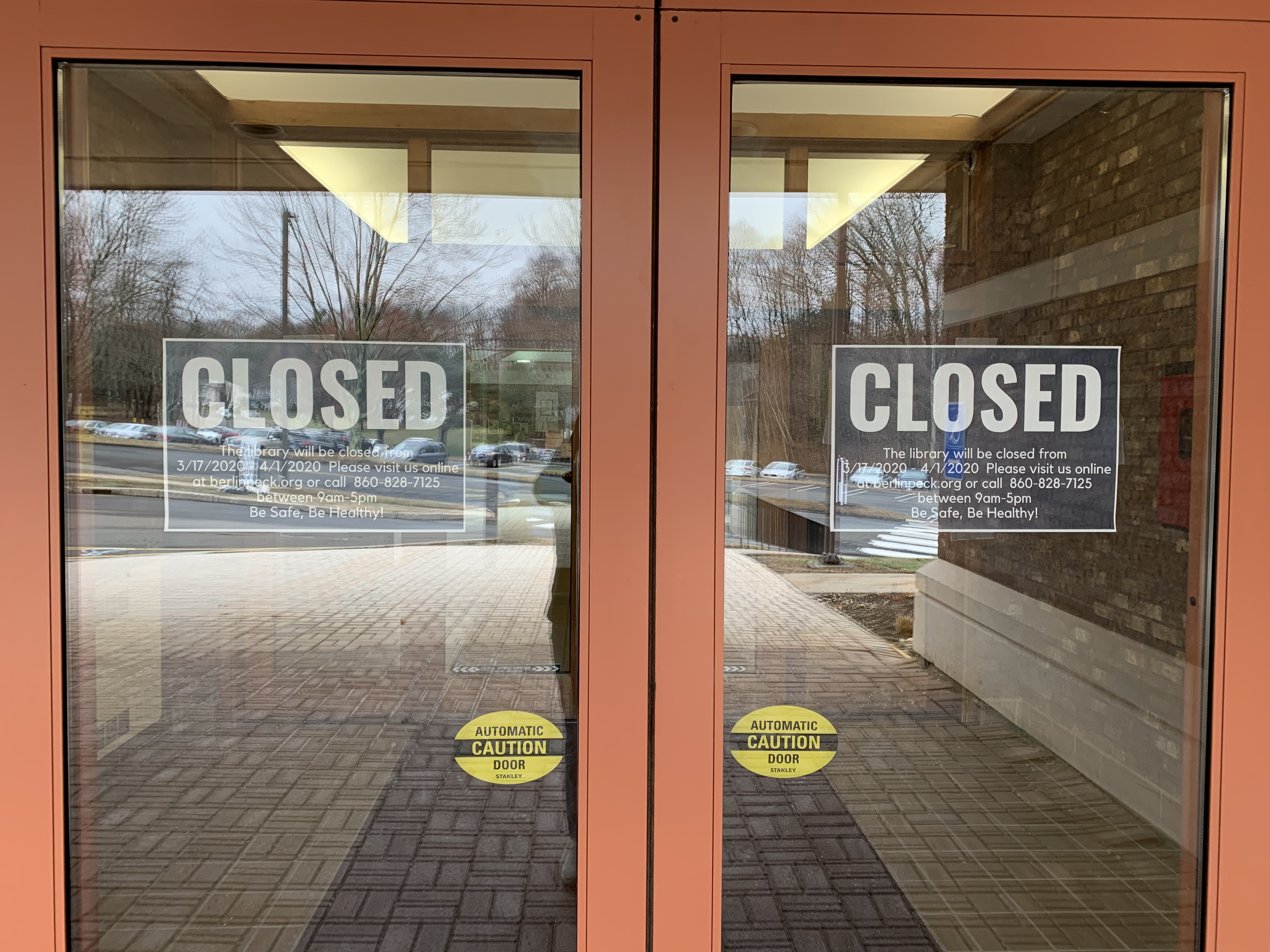Glass double doors with two signs that read 'CLOSED'