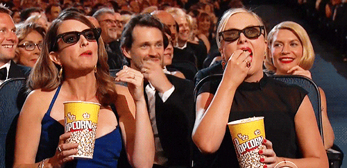 Tina Fey and Amy Poehler in audience eating popcorn